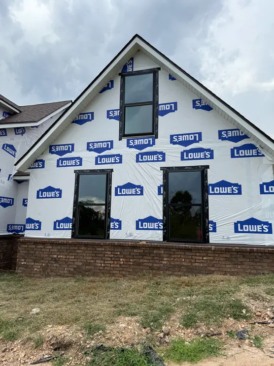 New construction windows installed in a gable wall wrapped in house wrap