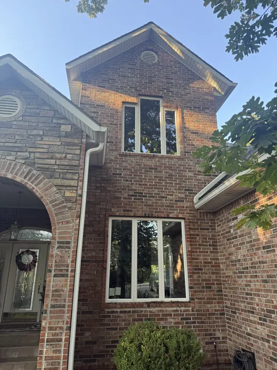 Brick home entry with white-frame windows