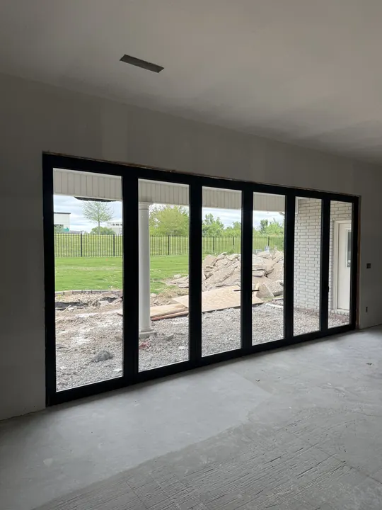 Interior view of a wall of black-frame multi-panel glass doors
