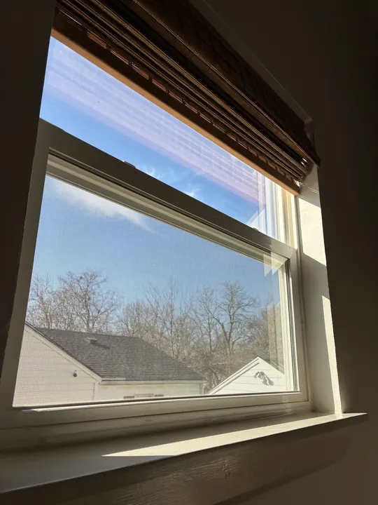 Interior view through a new white double window with the blind raised