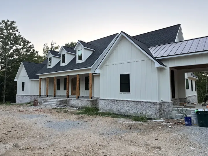 White farmhouse-style home with new black-frame windows